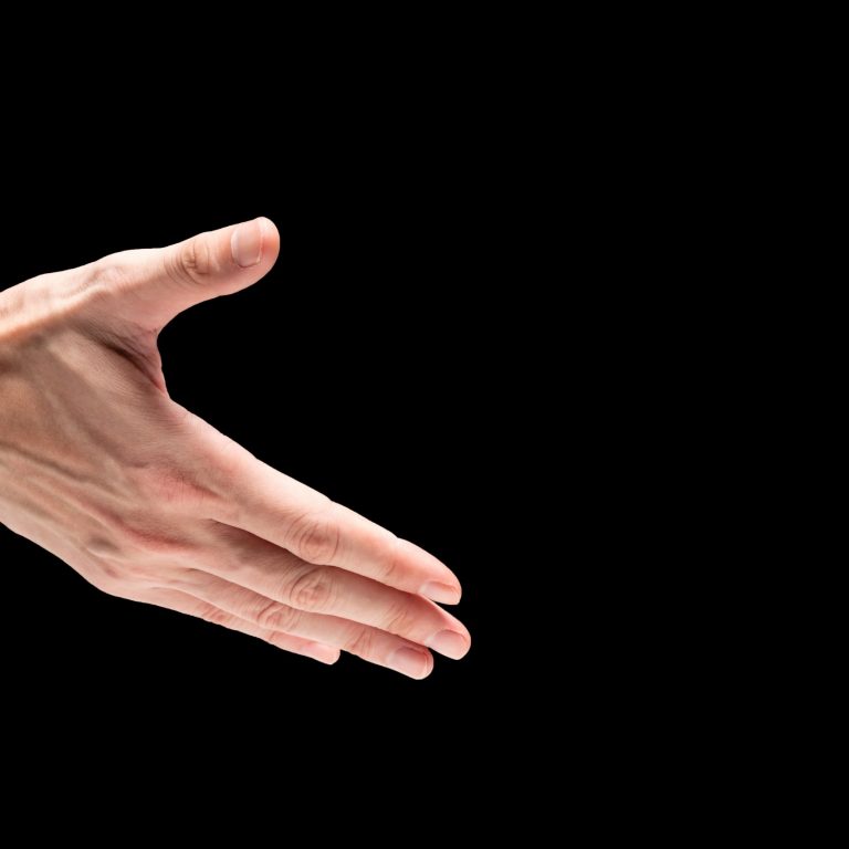 Male hand on a black background. Free space for text